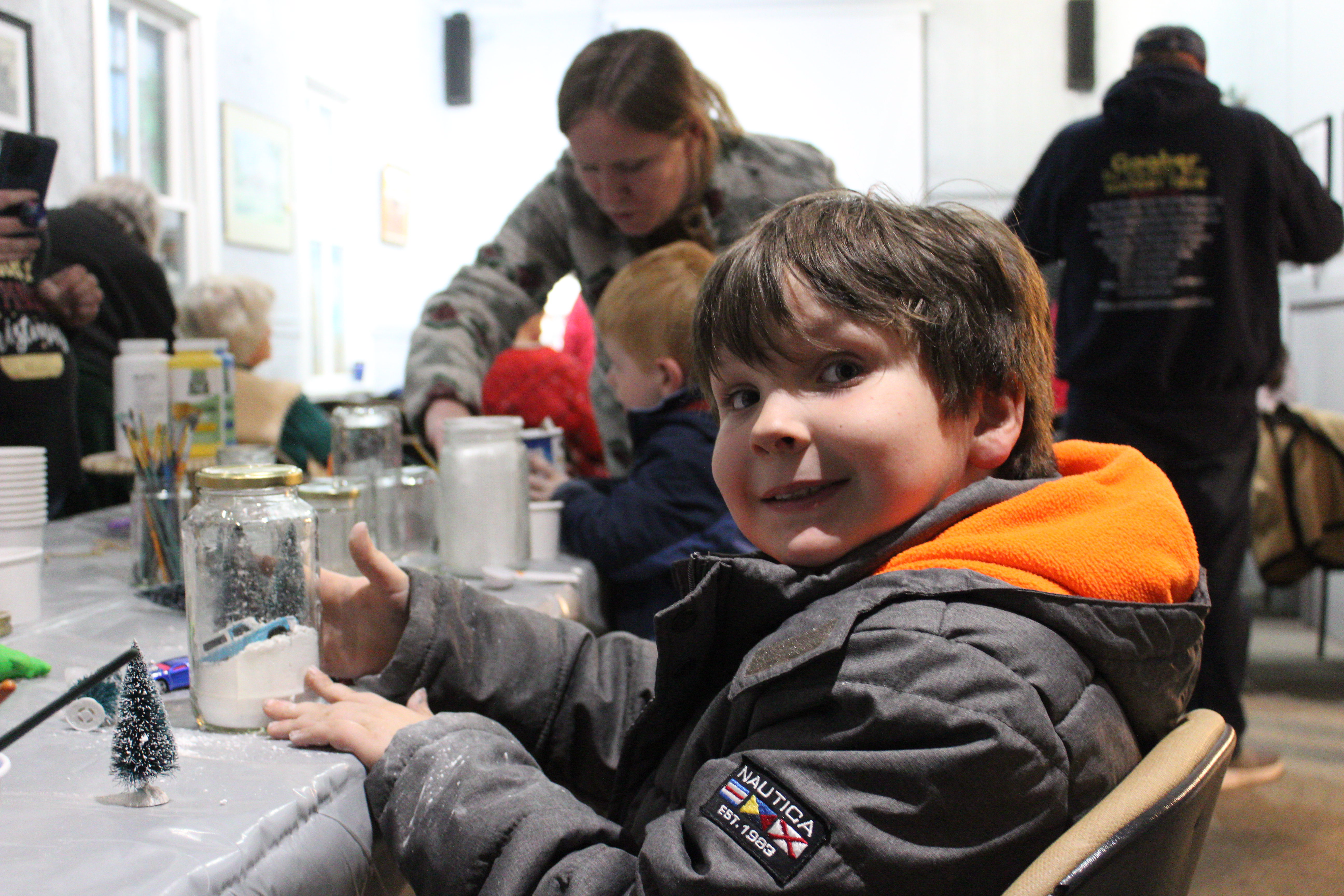 Families making ornaments and snow globes during Christmas at the Museum